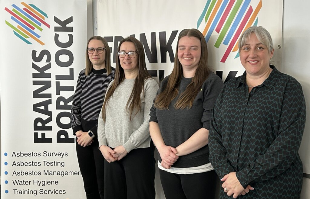 A photo of the women at the Scotland office, standing in a line, next to a Franks Portlock roller banner stand.